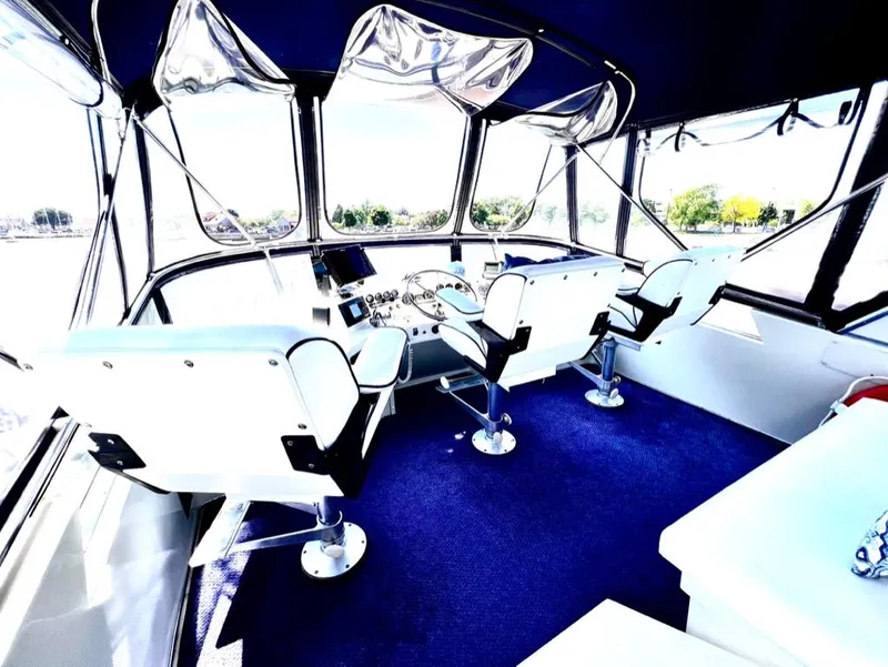 Slide: The Image of 1987 Tollycraft 44 Cockpit Motoryacht helm with blue carpet and white captain chairs. - 17