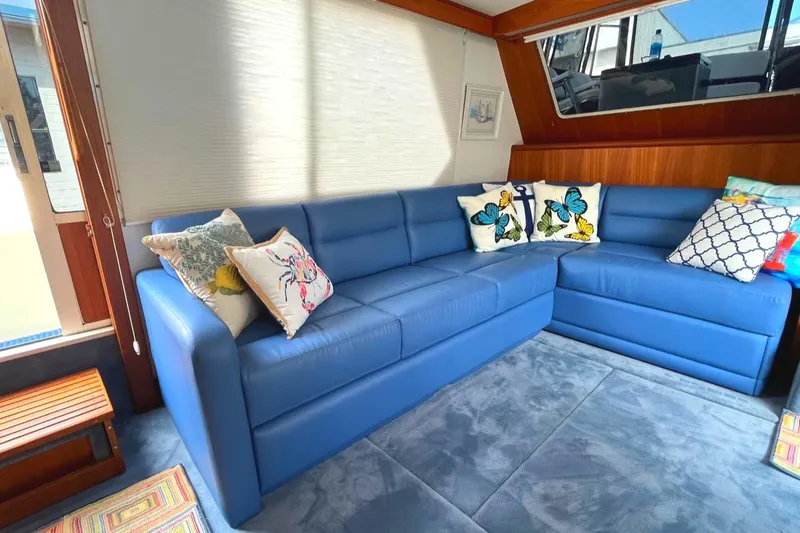 Slide: The Image of 1987 Tollycraft 44 Cockpit Motoryacht interior with blue sectional sofa and decorative pillows. - 22