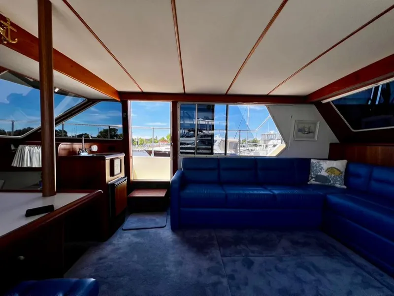 Slide: The Image of Interior of 1987 Tollycraft 44 Cockpit Motoryacht with blue seating and large windows. - 24