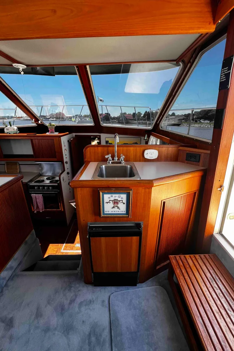 Slide: The Image of Interior of 1987 Tollycraft 44 Cockpit Motor Yacht with wooden cabinetry and sink. - 26