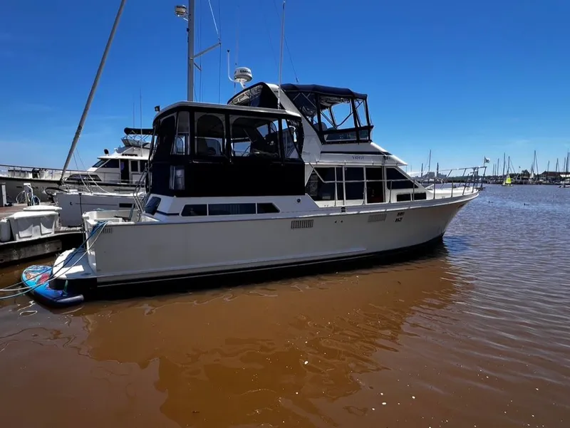 Slide: The Image of 1987 Tollycraft 44 Cockpit Motoryacht docked in a marina on a sunny day. - 3