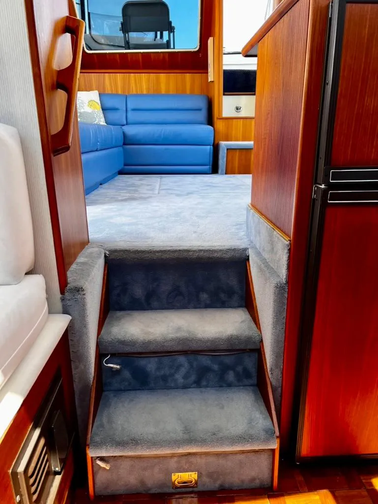 Slide: The Image of Interior of 1987 Tollycraft 44 Cockpit Motoryacht with blue carpeted steps and seating. - 31