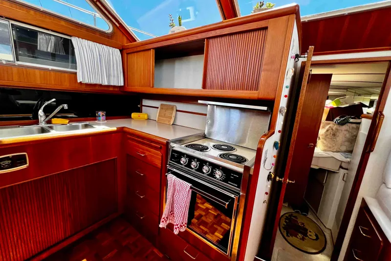 Slide: The Image of 1987 Tollycraft 44 Cockpit Motor Yacht kitchen with wood cabinetry and stove. - 33