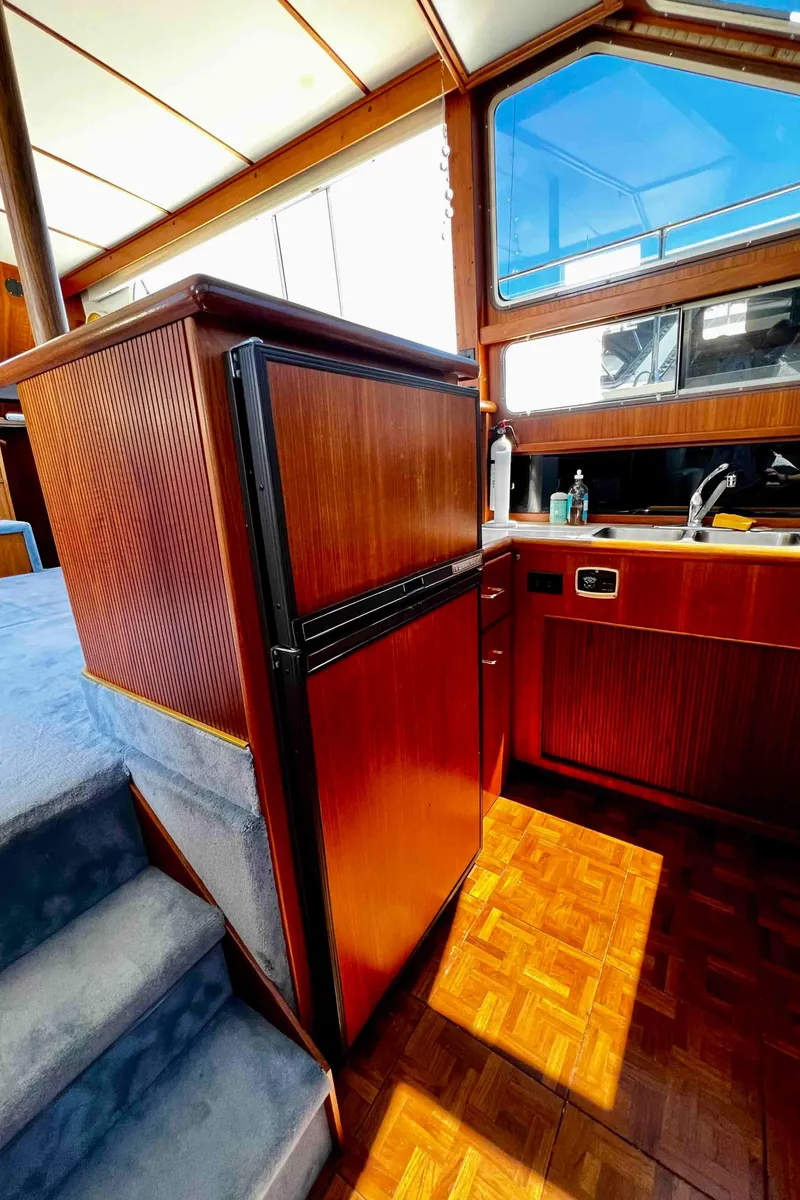 Slide: The Image of Interior of 1987 Tollycraft 44 Cockpit Motor Yacht with wood cabinetry and blue carpeted stairs. - 34