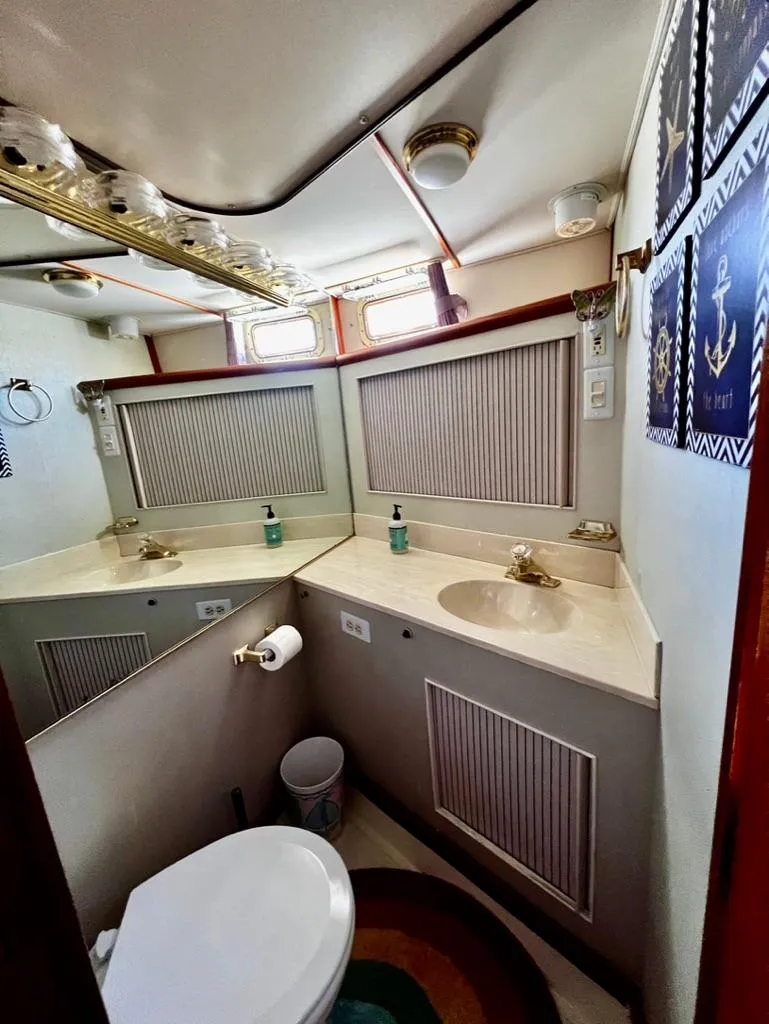 Slide: The Image of 1987 Tollycraft 44 Cockpit Motoryacht bathroom with sink, mirror, and toilet. - 40
