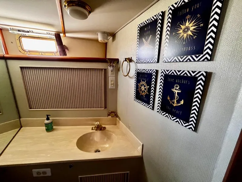 Slide: The Image of 1987 Tollycraft 44 Cockpit Motoryacht bathroom with nautical-themed wall art. - 41