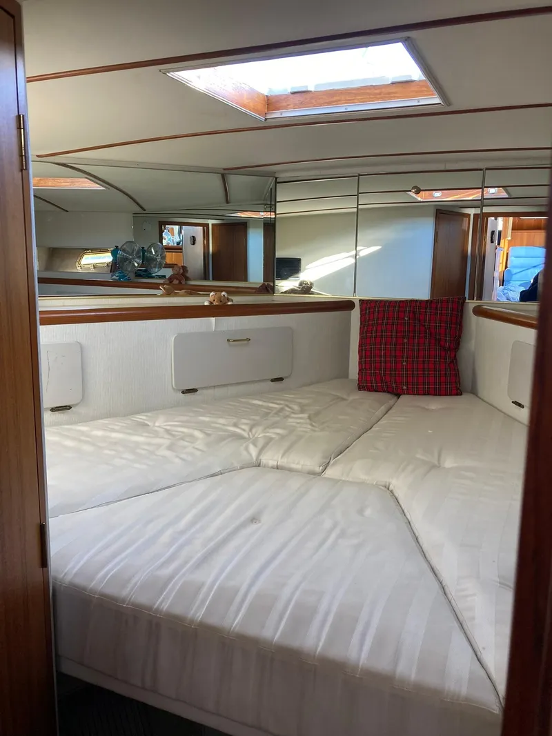 Slide: The Image of Interior of 1987 Tollycraft 44 Cockpit Motor Yacht with white bedding and skylight. - 43