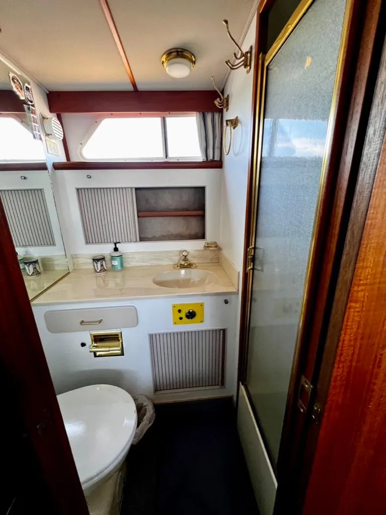 Slide: The Image of 1987 Tollycraft 44 Cockpit Motoryacht bathroom with sink, toilet, and shower. - 47