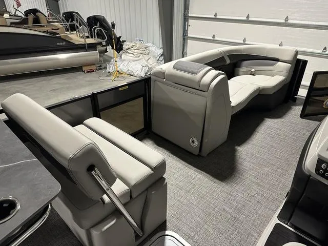 Slide: The Image of 2025 Barletta Boats Cabrio C24UE interior with luxurious seating in a showroom. - 11
