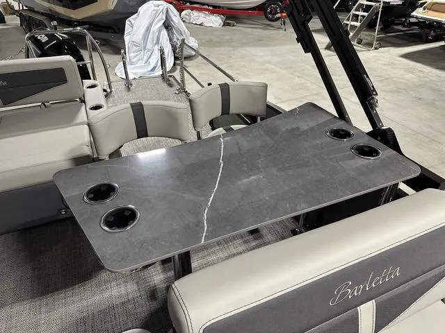 Slide: The Image of 2025 Barletta Boats Cabrio C24UE interior with sleek table and cup holders. - 16