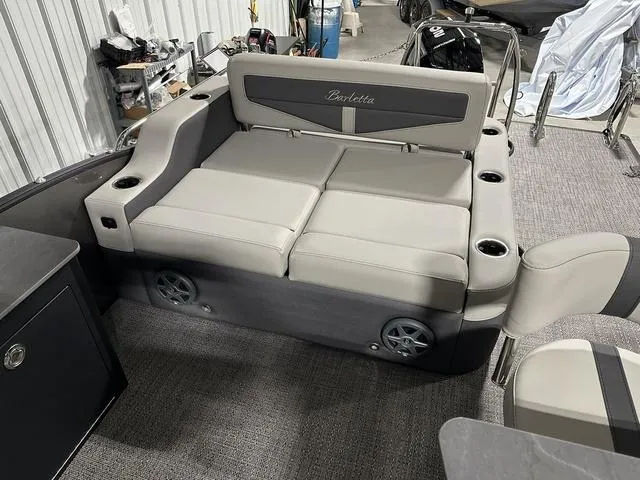 Slide: The Image of 2025 Barletta Boats Cabrio C24UE interior seating area with cup holders and storage. - 17