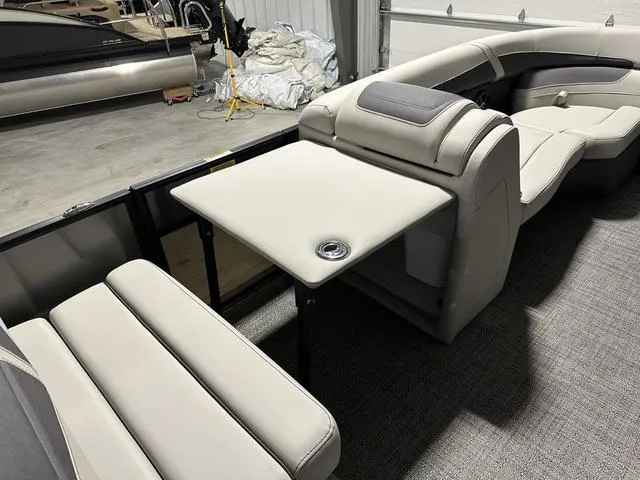 Slide: The Image of 2025 Barletta Boats Cabrio C24UE interior with beige seating and table. - 20