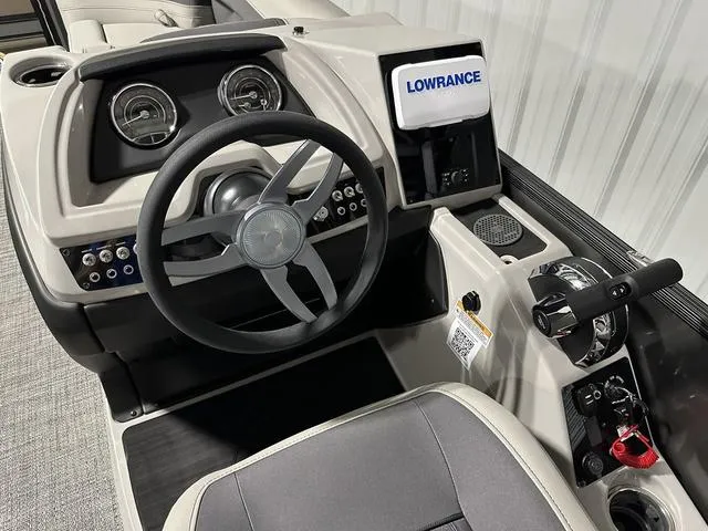 Slide: The Image of 2025 Barletta Boats Cabrio C24UE dashboard with steering wheel and Lowrance display. - 25