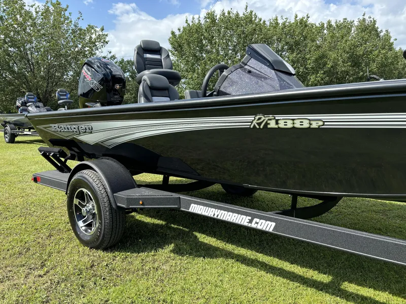 Slide: The Image of 2024 Ranger RT188P boat on trailer, parked on grass with trees in background. - 5
