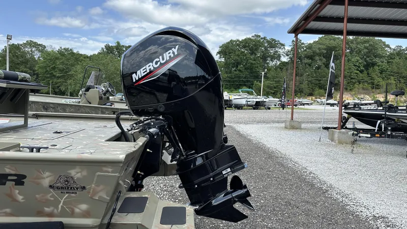 Slide: The Image of 2024 Tracker Grizzly 2072 CC SportMan with Mercury outboard motor in a boatyard. - 10