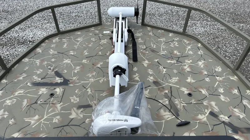 Slide: The Image of 2024 Tracker Grizzly 2072 CC SportMan boat with camo deck and trolling motor. - 13