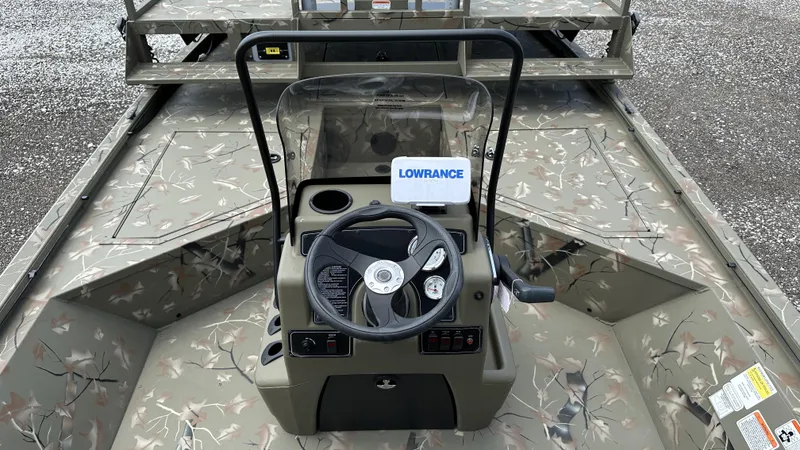 Slide: The Image of 2024 Tracker Grizzly 2072 CC SportMan boat interior with camo design and steering console. - 4