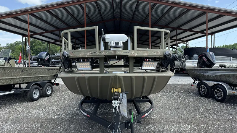 Slide: The Image of 2024 Tracker Grizzly 2072 CC SportMan boat displayed in a covered outdoor showroom. - 8