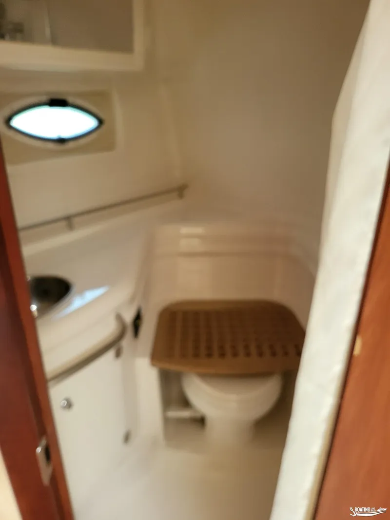 Slide: The Image of 2008 Monterey 350 Sport Yacht bathroom with toilet, sink, and porthole window. - 29