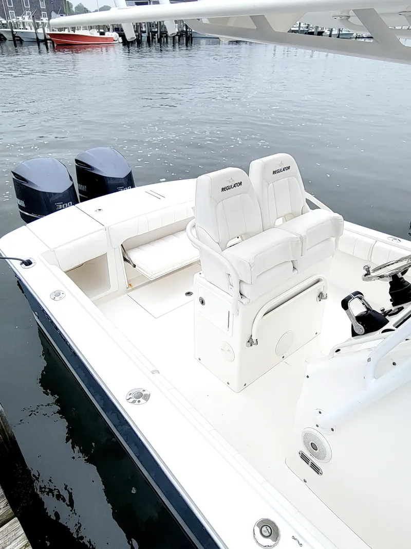 Slide: The Image of 2014 Regulator 28 Forward Seating boat with dual outboard motors docked. - 2