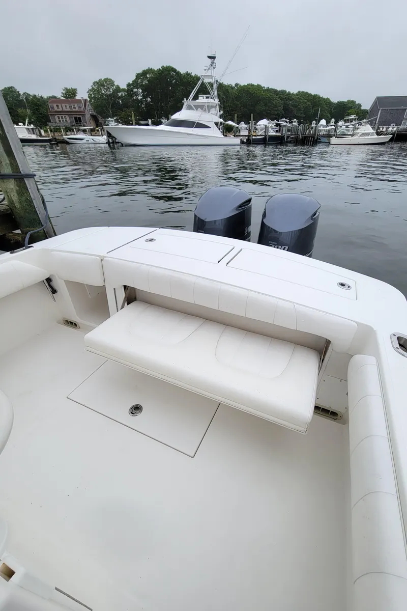 Slide: The Image of 2014 Regulator 28 Forward Seating boat with twin outboard motors docked in a marina. - 7