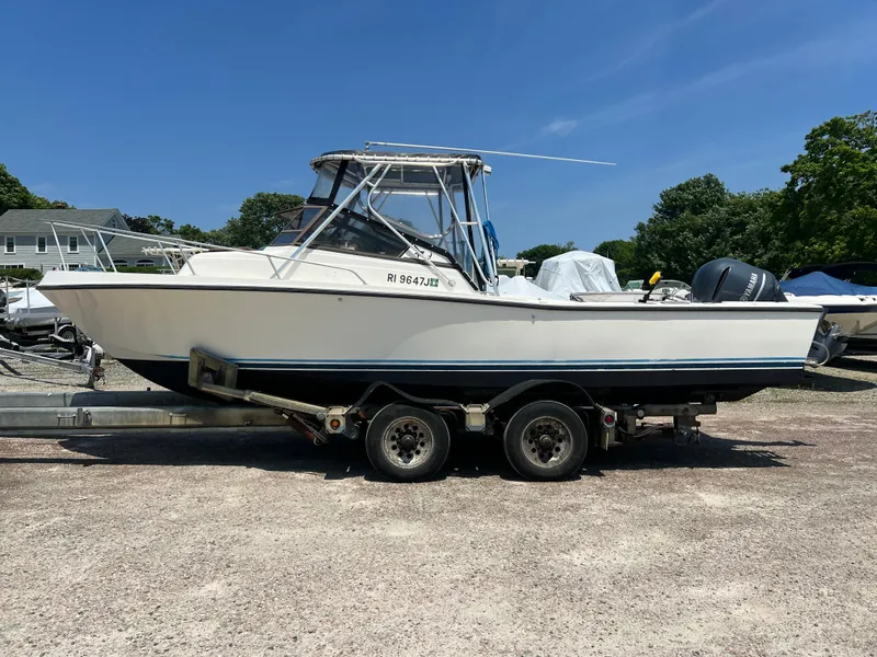Slide: The Image of 1985 Mako 258 Cuddy boat on a trailer in a sunny outdoor setting. - 1