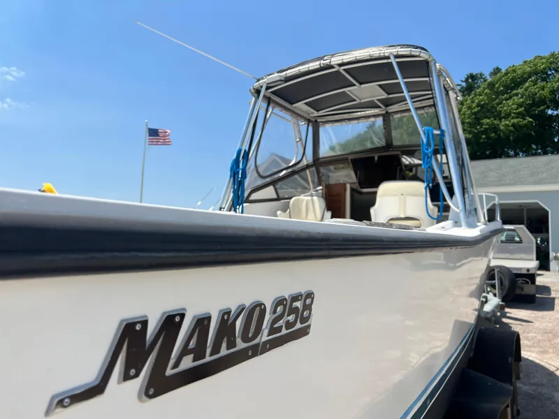 Slide: The Image of 1985 Mako 258 Cuddy boat with American flag in background. - 16