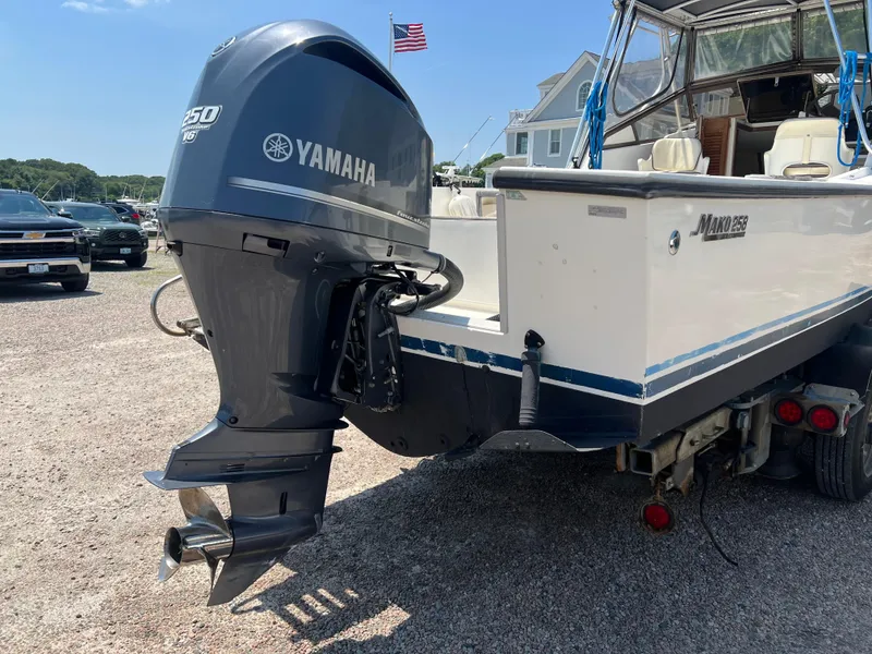 Slide: The Image of 1985 Mako 258 Cuddy boat with Yamaha 150 outboard motor in a marina. - 18