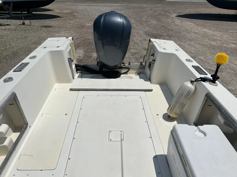 Slide: The Image of 1985 Mako 258 Cuddy boat deck with outboard motor and storage compartments. - 25