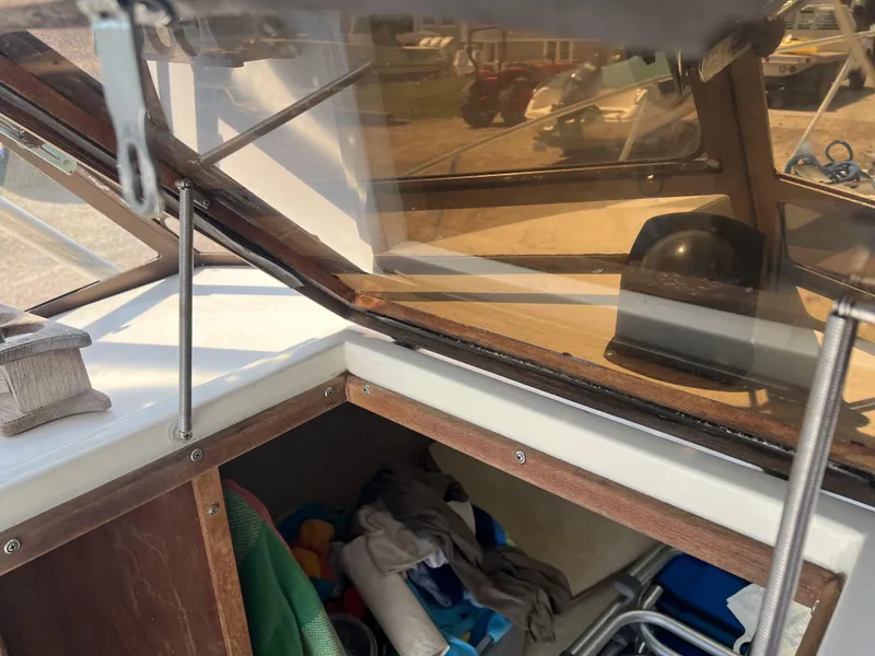 Slide: The Image of 1985 Mako 258 Cuddy cabin interior with windshield and storage area. - 26