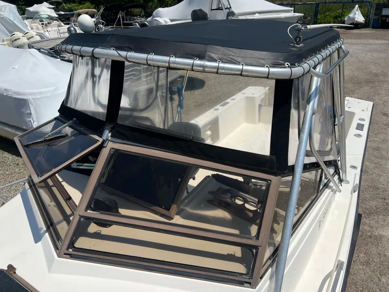 Slide: The Image of 1985 Mako 258 Cuddy boat with black canopy and open windows. - 33