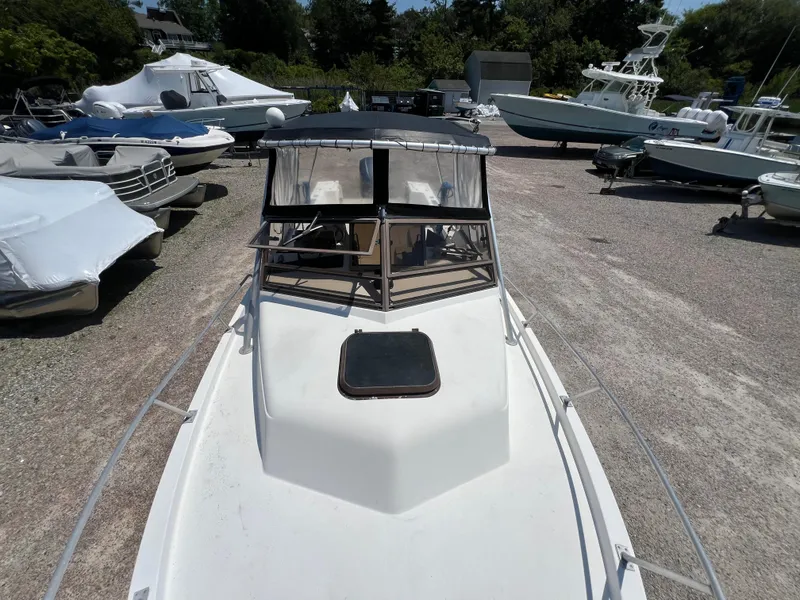Slide: The Image of 1985 Mako 258 Cuddy boat in a marina with other boats. - 35