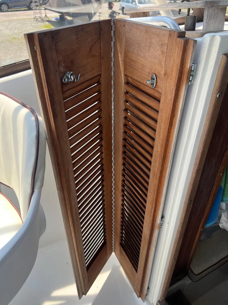 Slide: The Image of 1985 Mako 258 Cuddy wooden cabin doors on a boat. - 36