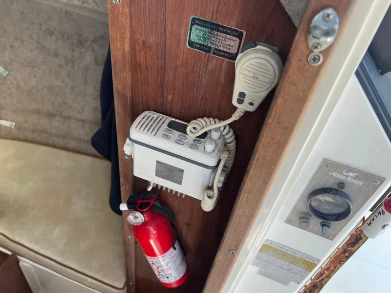 Slide: The Image of 1985 Mako 258 Cuddy interior with radio, fire extinguisher, and control panel. - 42