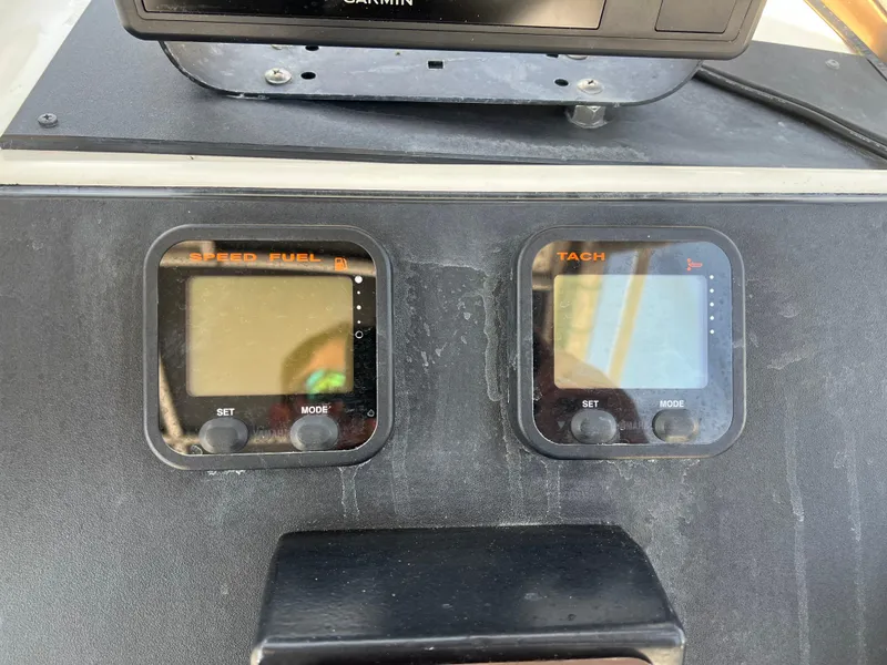 Slide: The Image of Digital fuel and tachometer gauges on a 1985 Mako 258 Cuddy boat dashboard. - 43