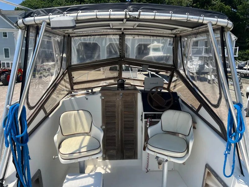Slide: The Image of 1985 Mako 258 Cuddy boat interior with helm and seating. - 9