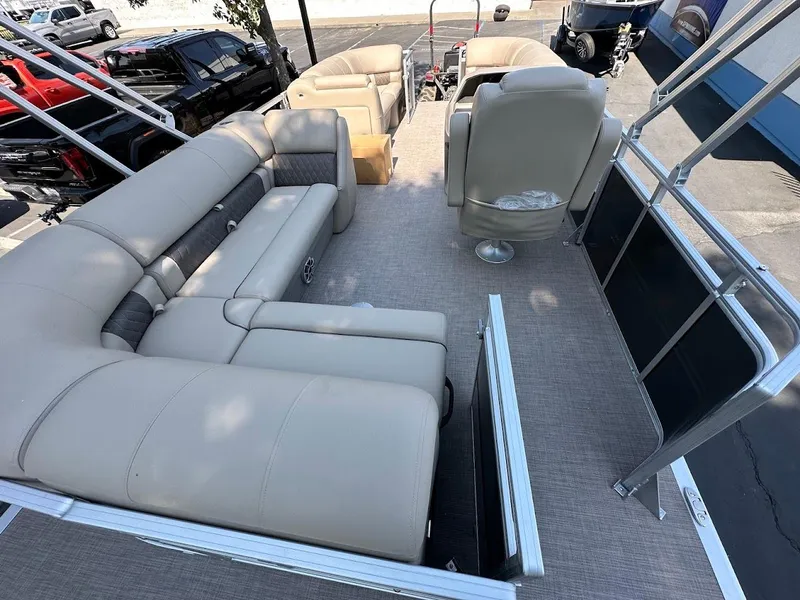 Slide: The Image of 2024 Sun Tracker Party Barge 20 DLX interior with beige seating and spacious layout. - 15
