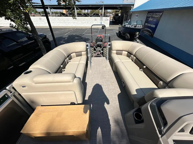 Slide: The Image of 2024 Sun Tracker Party Barge 20 DLX interior with beige seating and spacious layout. - 22