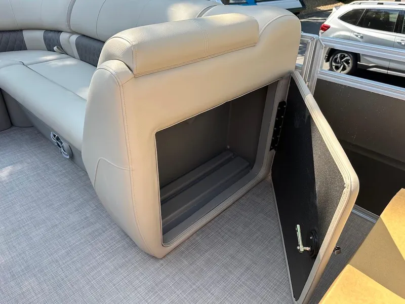 Slide: The Image of 2024 Sun Tracker Party Barge 20 DLX storage compartment with open seat and gray upholstery. - 29