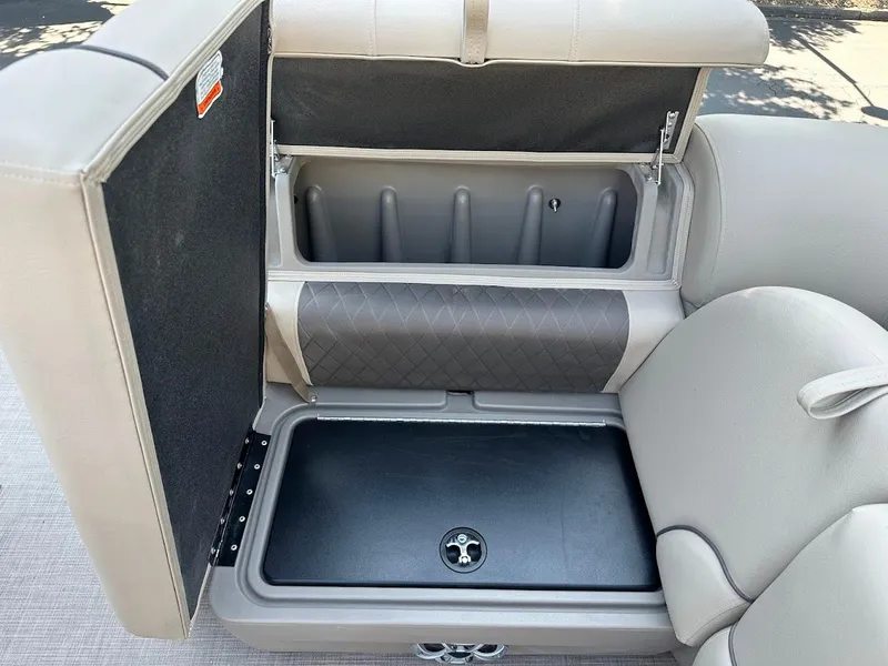 Slide: The Image of 2024 Sun Tracker Party Barge 20 DLX storage compartment with open seat and interior view. - 34