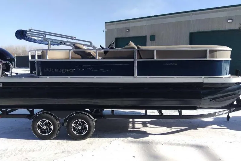 The Image of 2024 Ranger Reata 200C pontoon boat on trailer, parked outdoors. - 0