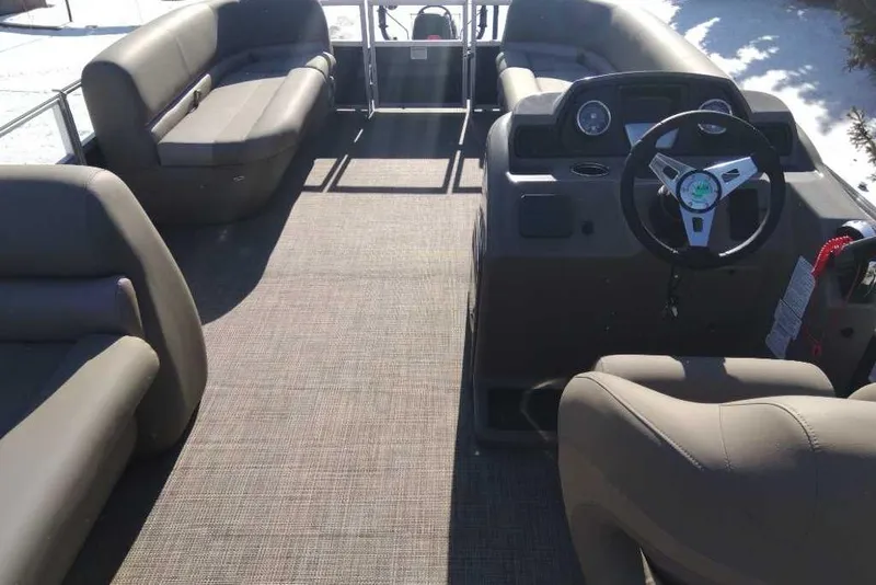 Slide: The Image of 2024 Ranger Reata 200C pontoon boat interior with spacious seating and modern steering console. - 2