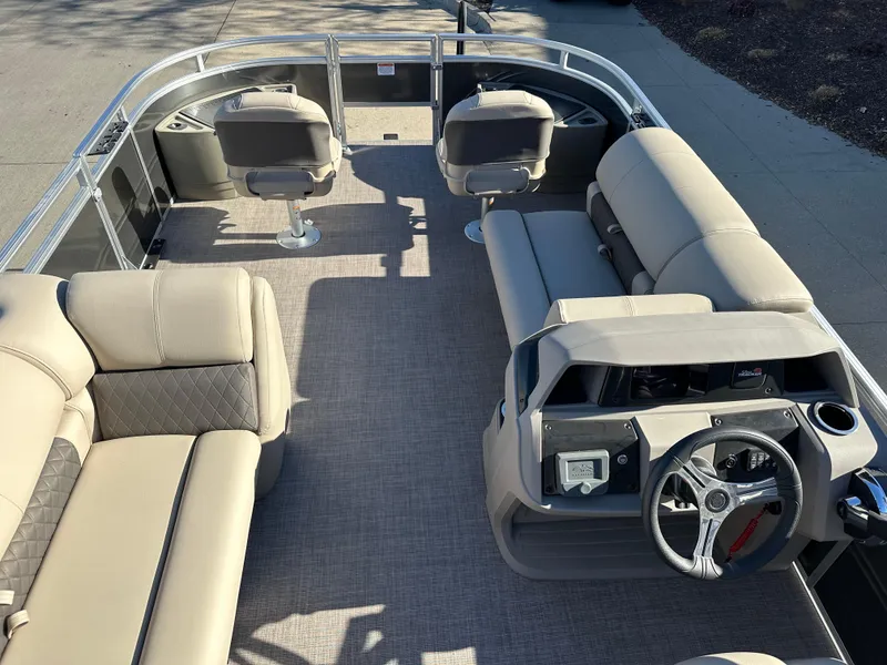 Slide: The Image of 2024 Sun Tracker Fishin' Barge 20 DLX interior with beige seating and steering console. - 3