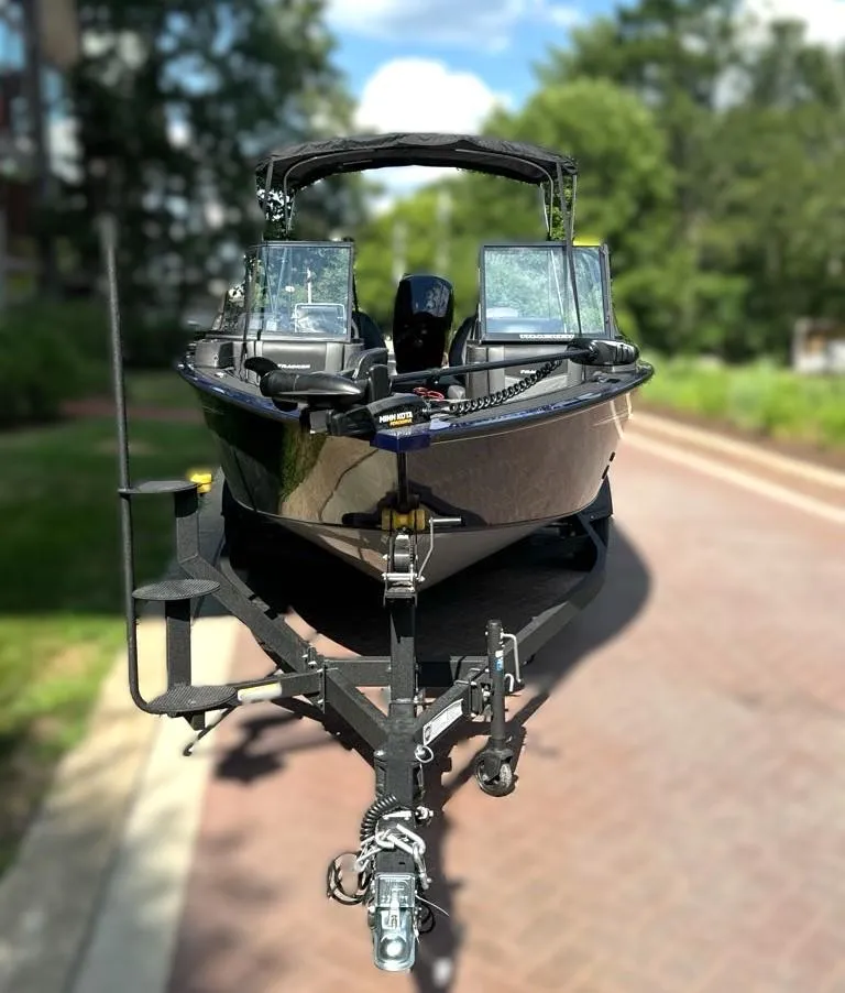 Slide: The Image of 2024 Tracker Targa V-18 WT boat on a trailer, parked on a sunny street. - 2