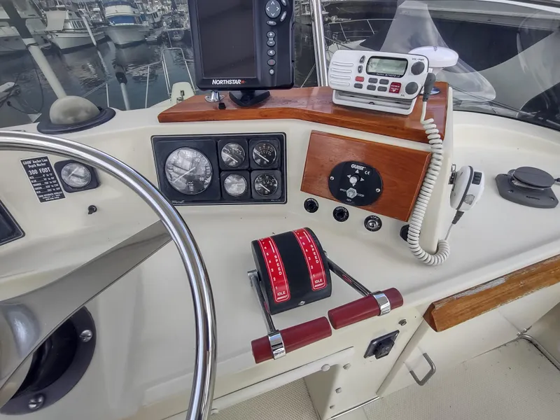 Slide: The Image of 1988 Tollycraft 34 Sport Sedan helm with gauges, controls, and marine electronics. - 29