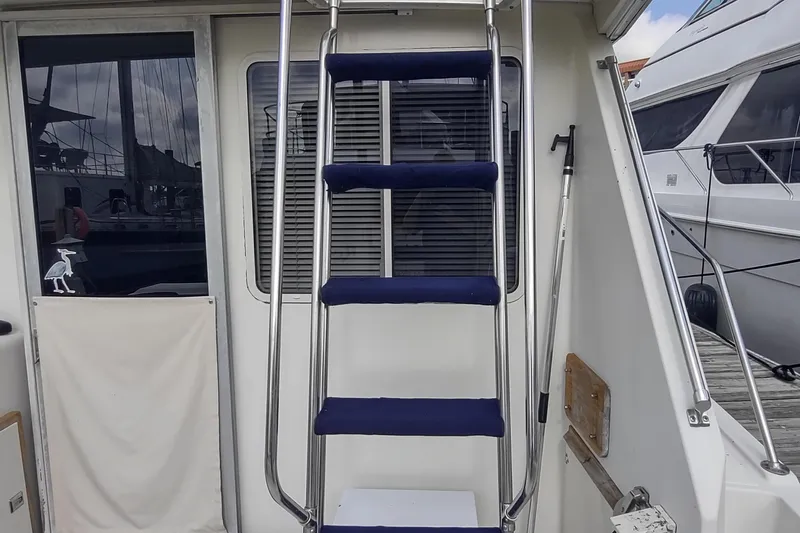 Slide: The Image of 1988 Tollycraft 34 Sport Sedan boat ladder and rear deck area. - 27