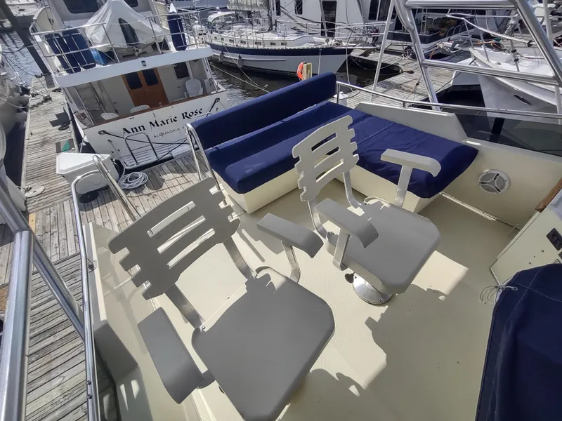 Slide: The Image of 1988 Tollycraft 34 Sport Sedan boat deck with seating at marina. - 35