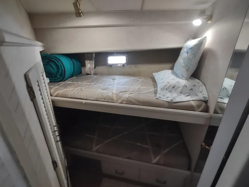 Slide: The Image of 1988 Tollycraft 34 Sport Sedan cabin with bunk beds and porthole. - 17