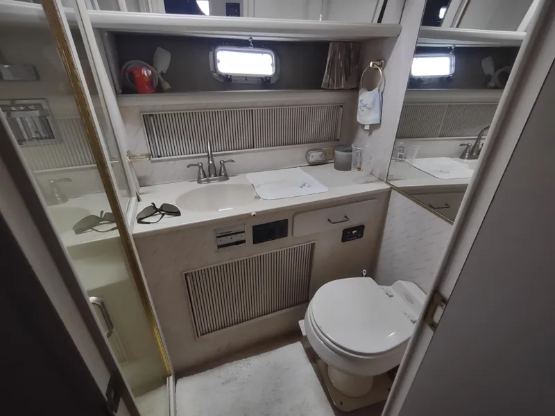 Slide: The Image of 1988 Tollycraft 34 Sport Sedan bathroom with sink, toilet, and mirror. - 19