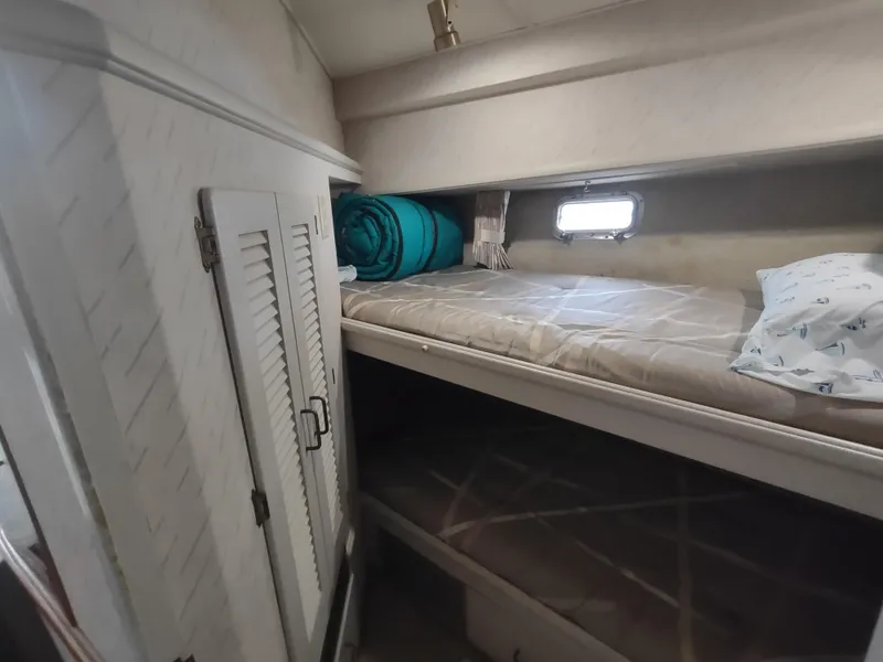 Slide: The Image of 1988 Tollycraft 34 Sport Sedan cabin with bunk beds and storage. - 18